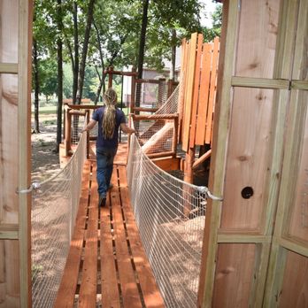 Treehouse Experts - a young girl walking through a treehouse - General Contractors Near Me Treehouse Experts - a young girl walking through a treehouse - General Contractors Near Me