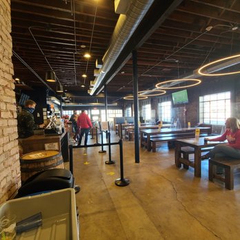 Marshall Brewing Tap Room - a woman sitting on a bench - Breweries Near Me - Tulsa, Oklahoma Marshall Brewing Tap Room - a woman sitting on a bench - Breweries Near Me - Tulsa, Oklahoma