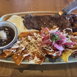 Chilaquiles with red sauce and added steak.