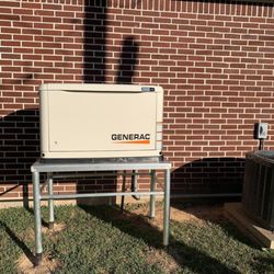 A & A Electric Company of Beaumont - A beige Generac generator is mounted on a metal stand against a red brick wall. An air conditioning unit is visible to the ri...