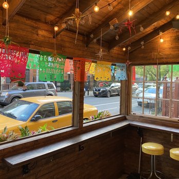 Quesadillas Doña Maty - a view of a street through a window - Mexican Near Me - New York, New York