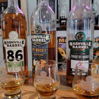 Nashville Barrel - three bottles of bourbon and two glasses of whiskey - Distilleries Near Me - Nashville, Tennessee