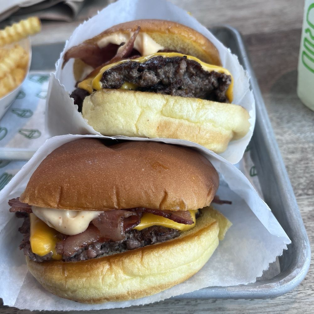 Shake Shack Long Beach - (On top) Double ShackBurger with bacon (on bottom) ShackBurger with bacon - Burgers Near Me - Long Beach, California Shake Shack Long Beach - (On top) Double ShackBurger with bacon (on bottom) ShackBurger with bacon - Burgers Near Me - Long Beach, California