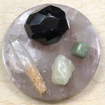 House of NteKKah - 4 of my finds resting on a charging plate (Garnet meatball, green garnet, sulfur, blue smoke quartz with Cookeite) - Spiritual Shop Near Me - Augusta, Georgia House of NteKKah - 4 of my finds resting on a charging plate (Garnet meatball, green garnet, sulfur, blue smoke quartz with Cookeite) - Spiritual Shop Near Me - Augusta, Georgia