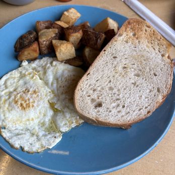 The Sunshine Diner - 2 eggs with homefries and just showing one of the many pieces of local sourdough toast that comes with the meal - Breakfast & Brunch Near Me - Bolton Landing, New York The Sunshine Diner - 2 eggs with homefries and just showing one of the many pieces of local sourdough toast that comes with the meal - Breakfast & Brunch Near Me - Bolton Landing, New York