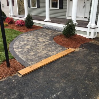 Doherty Landscaping - a driveway with a block paver and a wooden step leading to the front door - Landscaping Near Me - Woburn, Massachusetts