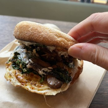 Dahlia Bakery - A close up on the veggie (kale and mushroom) and egg breakfast sandwich with truffle cheese and black pepper aioli. - Bakeries Near Me - Seattle, Washington