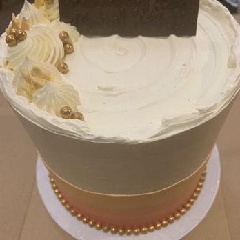 MackBox - Kitty cake - A round birthday cake with white frosting, gold pearl decorations, and a chocolate plaque with a birthday message on top. - Desserts Near Me