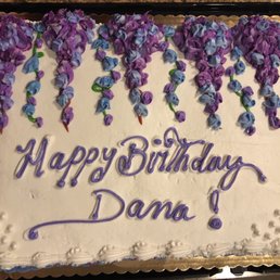 a birthday cake decorated with purple and blue flowers