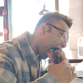 Fiya Hen - Here's my friend eating the fried chicken sandwich with truffle fries - Chicken Wings Near Me - Boston, Massachusetts