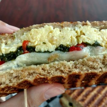 Fresco Foodworks - The insides of a Pesto Paradise Panini.   Baby spinach, roasted red peppers, pesto aioli, provolone..  obviously eggs, on multi-grain bread. - Coffee & Tea Near Me - Boca Raton, Florida