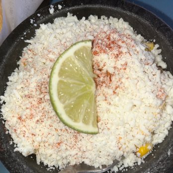 Crescent Ballroom - Elote - A serving of Mexican street corn (elote) in a black bowl, topped with crumbled cheese, chili powder, and garnished with a lime wedge. - Music Venues Near Me - Phoenix, Arizona