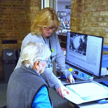Vision Forward Association - Older woman is getting a demo of a desktop video magnifier and looking at printed materials - Rehabilitation Center Near Me - West Allis, Wisconsin Vision Forward Association - Older woman is getting a demo of a desktop video magnifier and looking at printed materials - Rehabilitation Center Near Me - West Allis, Wisconsin