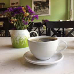 a cup of coffee and a vase of flowers a cup of coffee and a vase of flowers