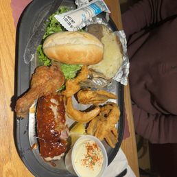 Sharing plate of ribs, chicken and perch with baked potato and home baked roll.