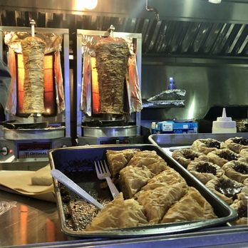 The Greek - a man preparing food in the kitchen - Greek Near Me The Greek - a man preparing food in the kitchen - Greek Near Me