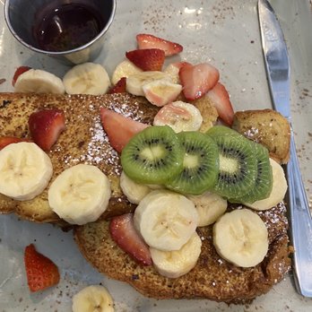 First Watch - Two pieces brioche bread with wheat germ and powdered cinnamon sugar, covered with fresh banana, kiwi and seasonal berries. - Breakfast & Brunch Near Me - Jupiter, Florida