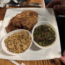 Pork chop, greens and dirty rice.