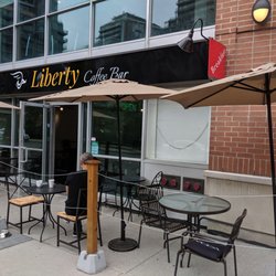 Liberty Coffee Bar - Out front of the restaurant from the sidewalk to the east looking west at the front entrance & patio seating area. August 2019