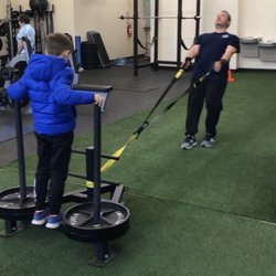 CoachMeFit - Northville CoachMeFit Client, Frank pulling his son on a backwards sled drag.