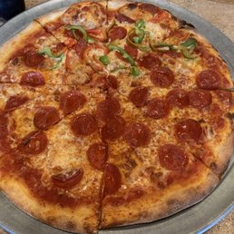Large pepperoni pizza with peppers on half
