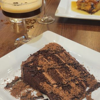 Gilded Feather - Chocolate Cake with Peach Bread Pudding in the background - American Near Me - Omaha, Nebraska Gilded Feather - Chocolate Cake with Peach Bread Pudding in the background - American Near Me - Omaha, Nebraska