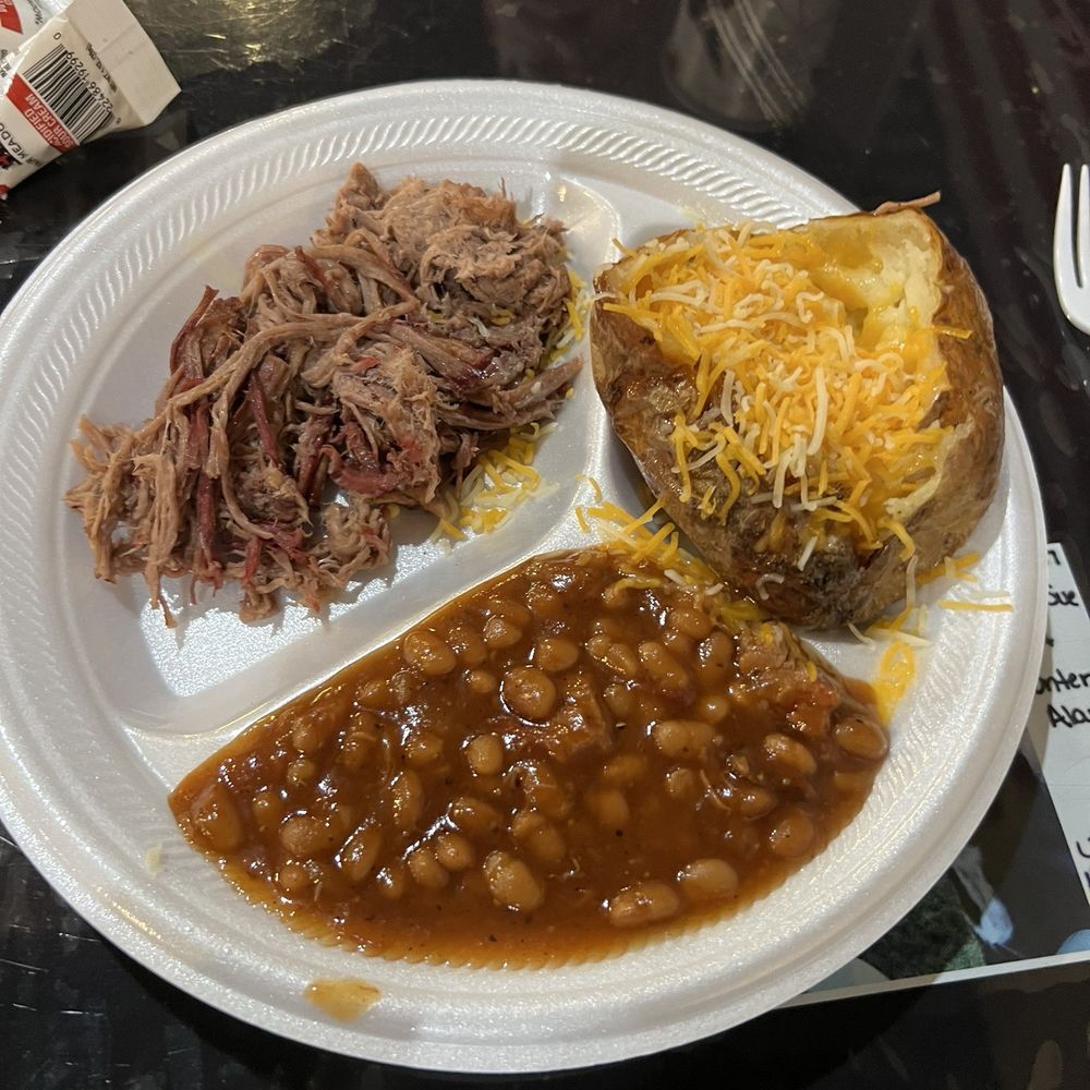 Brisket entrée with a loaded baked potato and baked beans Brisket entrée with a loaded baked potato and baked beans