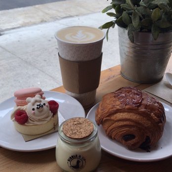 Bibble & Sip - left: lucky llama macaron & raspberry tart front center: matcha panna cotta jar back center: earl grey right: chocolate croissant - Coffee & Tea Near Me - New York, New York Bibble & Sip - left: lucky llama macaron & raspberry tart front center: matcha panna cotta jar back center: earl grey right: chocolate croissant - Coffee & Tea Near Me - New York, New York