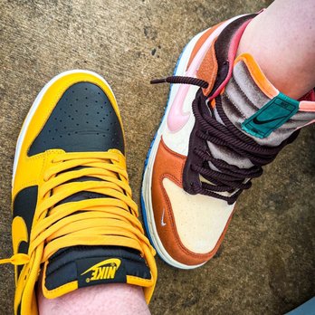 Old Town Temecula - Chillen at the Cuban cafe with kicks of the day! - A person is wearing two Nike sneakers, one yellow and black, the other brown and cream, on a concrete floor. - Local Flavor Near Me - Temecula, California