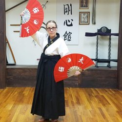 Art of Martial Arts East - Sensei Lehmuth (senior) posing with her weapons (traditional fans)