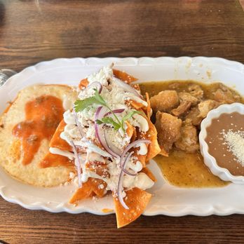 D' La Santa - Chilaquiles rojos added chicharrones with over easy egg - Mexican Near Me - Seattle, Washington