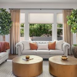 Budget Blinds of Mequon - Light-filtering cellular shades paired with custom drapery create a cozy, energy-efficient living room.