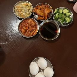 Banchan (side dishes) and the eggs to be cracked into the tofu soup Banchan (side dishes) and the eggs to be cracked into the tofu soup