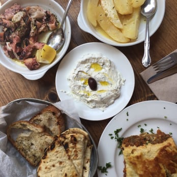Kiki's - Clockwise from top left - grilled octopus, lemon potatoes, tzaziki, mousaka, grilled pita bread. - Greek Near Me - New York, New York Kiki's - Clockwise from top left - grilled octopus, lemon potatoes, tzaziki, mousaka, grilled pita bread. - Greek Near Me - New York, New York