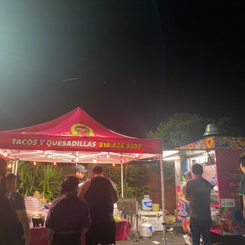 Taco Y Quesadilla - a group of people standing under a tent - Food Trucks Near Me
