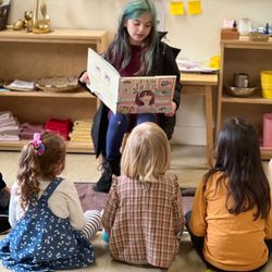 Puddletown Montessori School - A Puddletown elementary student visits one of the preschool/kindergarten classrooms and reads a book aloud,