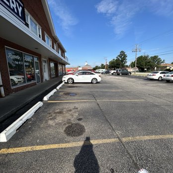 Allegretti's Bakery - An outdoor parking lot with several parked cars in front of a commercial building under a blue sky with some clouds. - Bakeries Near Me - Norridge, Illinois