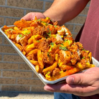 FOMO Fries - a person holding a tray of fries - Asian Fusion Near Me - Maywood, California