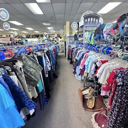 Isle of many varieties of clothing , baskets Above is furniture, backpacks , and baby bed Isle of many varieties of clothing , baskets Above is furniture, backpacks , and baby bed