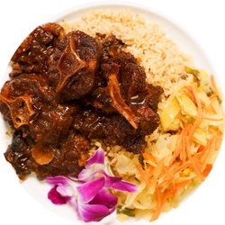 Braised oxtail stew down in a brown sauce, rice and peas, and steamed cabbage, cooked to perfection
