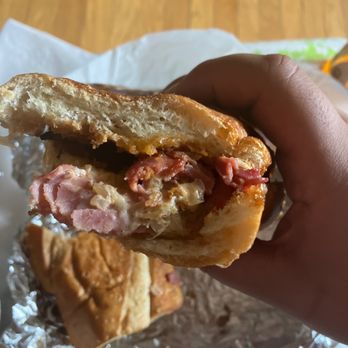Pizza And Grill | Denver Pizza - a hand holding a half eaten sandwich - Pizza Near Me - Denver, Colorado
