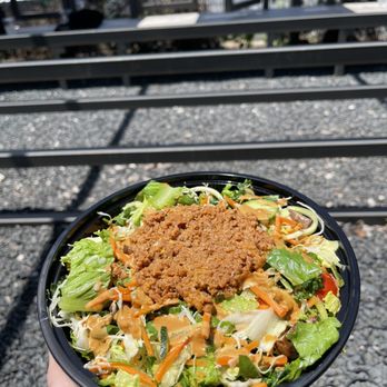Doshi House - a hand holding a bowl of salad - Coffee & Tea Near Me - Houston, Texas