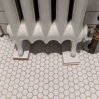 Regency Design & Build - Did not manage to level floor with radiator so propped up with pieces of tile? - Roofing Near Me - Cleveland Heights, Ohio Regency Design & Build - Did not manage to level floor with radiator so propped up with pieces of tile? - Roofing Near Me - Cleveland Heights, Ohio