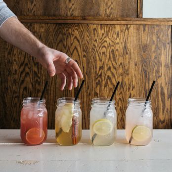 Brown Bag Seafood - a person placing lemon slices in mason jars - Seafood Near Me - Chicago, Illinois Brown Bag Seafood - a person placing lemon slices in mason jars - Seafood Near Me - Chicago, Illinois