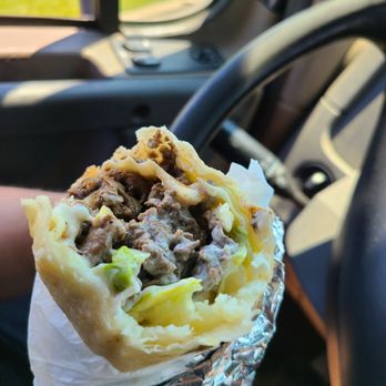 Burrito Los Azaderos & Mariscos - a hand holding a burrito - Mexican Near Me - St. Charles, Illinois