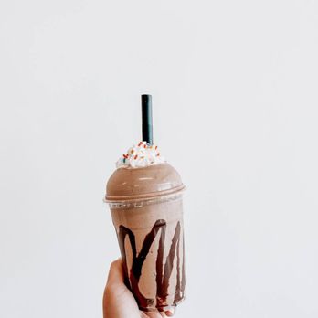 Village Nutrition - a hand holding a chocolate milkshake - Coffee & Tea Near Me - Grosse Pointe, Michigan Village Nutrition - a hand holding a chocolate milkshake - Coffee & Tea Near Me - Grosse Pointe, Michigan
