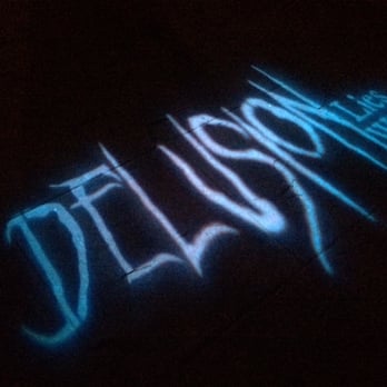 DELUSION - Ghostly logo projected onto the ground. - Performing Arts Near Me - Los Angeles, California DELUSION - Ghostly logo projected onto the ground. - Performing Arts Near Me - Los Angeles, California