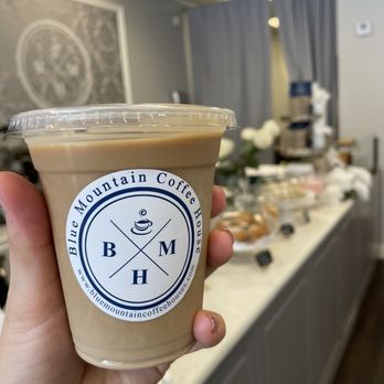 Blue Mountain Coffee House - a hand holding a cup of coffee - Coffee & Tea Near Me - West Palm Beach, Florida
