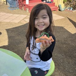 Seeds of Tomorrow Preschool - Outdoor fun! Little learner enjoys play dough time, shaping bright pumpkins and exploring creativity through hands-on learning.