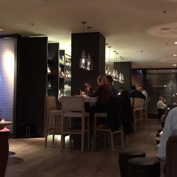 Crowne Plaza - Lobby bar at dusk is lively yet intimate and MODERN. I can relax here and feel like I fit in. - Hotels Near Me - Geneva, GE Crowne Plaza - Lobby bar at dusk is lively yet intimate and MODERN. I can relax here and feel like I fit in. - Hotels Near Me - Geneva, GE